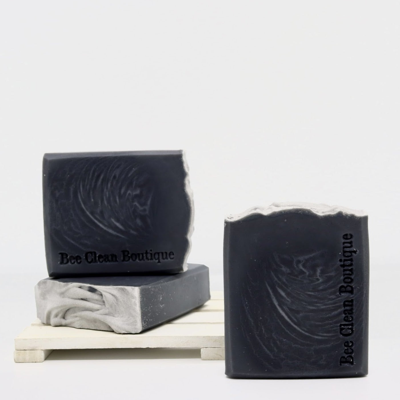 3 bars of black vetiver oak moss artisan soap displayed on white surface