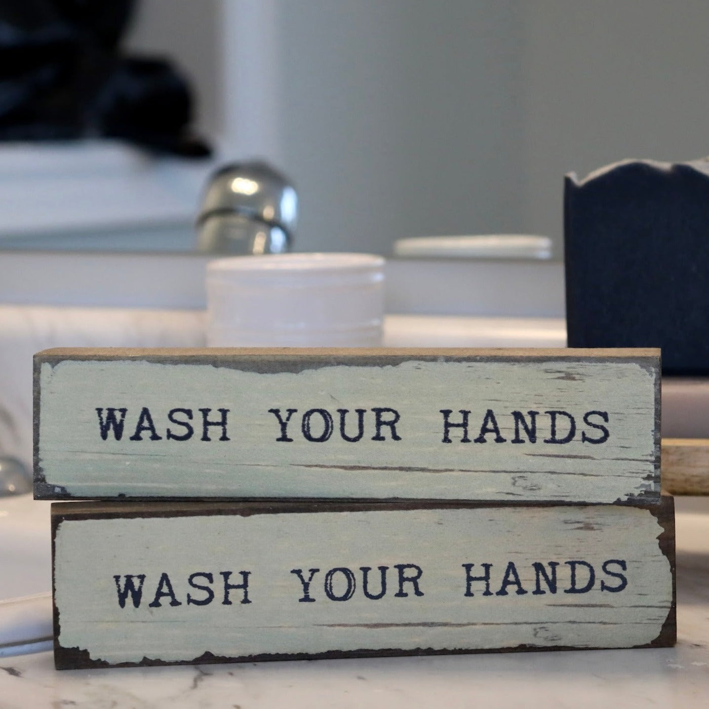 2 timber bits that say Wash Your Hands on a bathroom counter