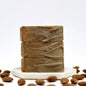 Stack of honey almond milk bars of soap on a small platter surrounded by almonds