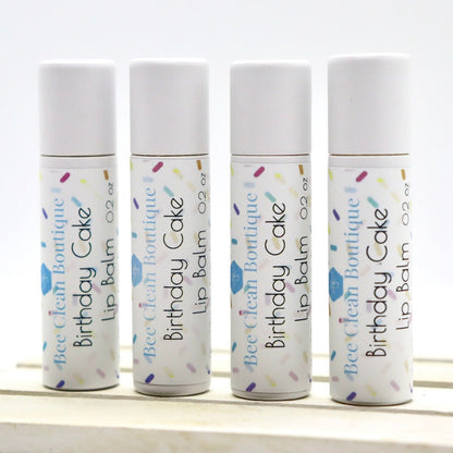 Four small tubes of Birthday Cake flavor lip balm standing in a row