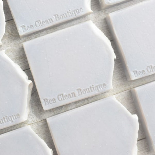 flat lay of white coastal mist artisan made bar soaps on a white wooden surface