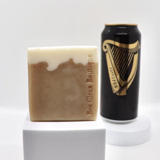 Coffee stout beer displayed on a small white platform in front of a can of stout