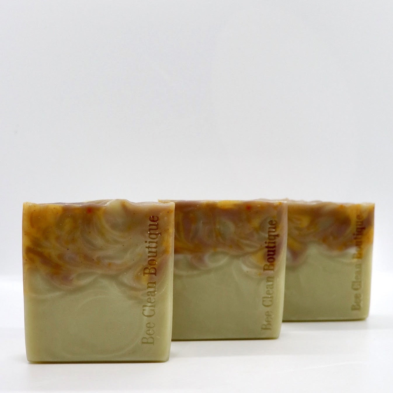 3 bars of orange patchouli handmade soap on display on white surface
