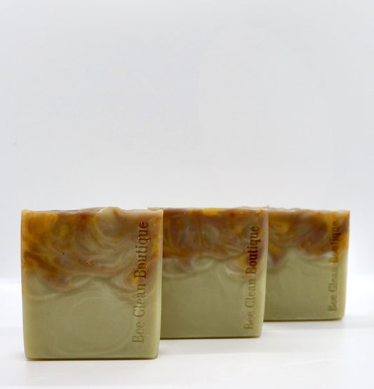 3 bars of orange patchouli artisan bar soaps lined up on a white surface