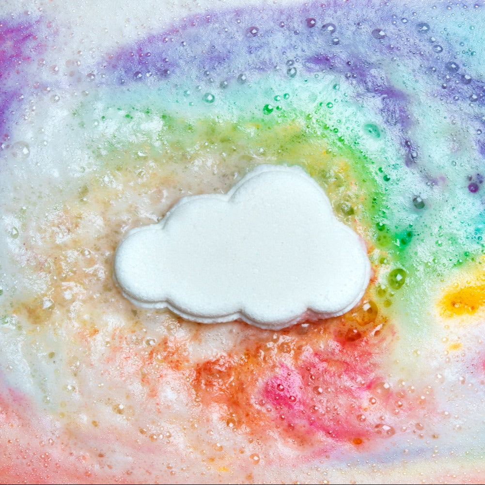 A cloud shaped bath bomb in a colourful swirl of bath water