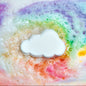 A cloud shaped bath bomb in a colourful swirl of bath water