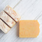 4 bars of clementine handmade soap displayed on a white wooden surface